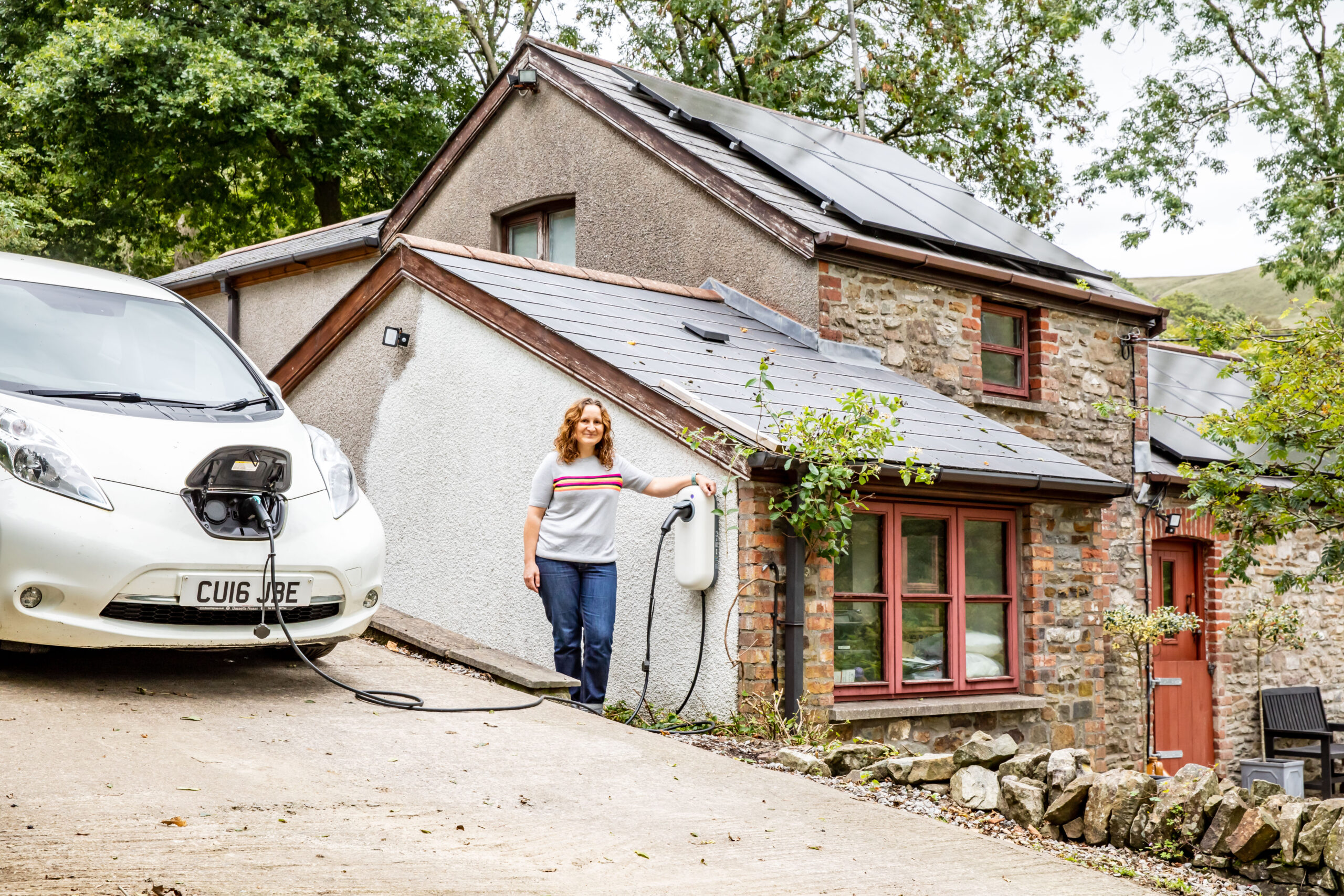 Woman charging electric car at home